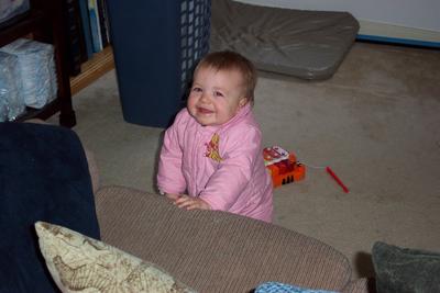 Sarah standing against couch